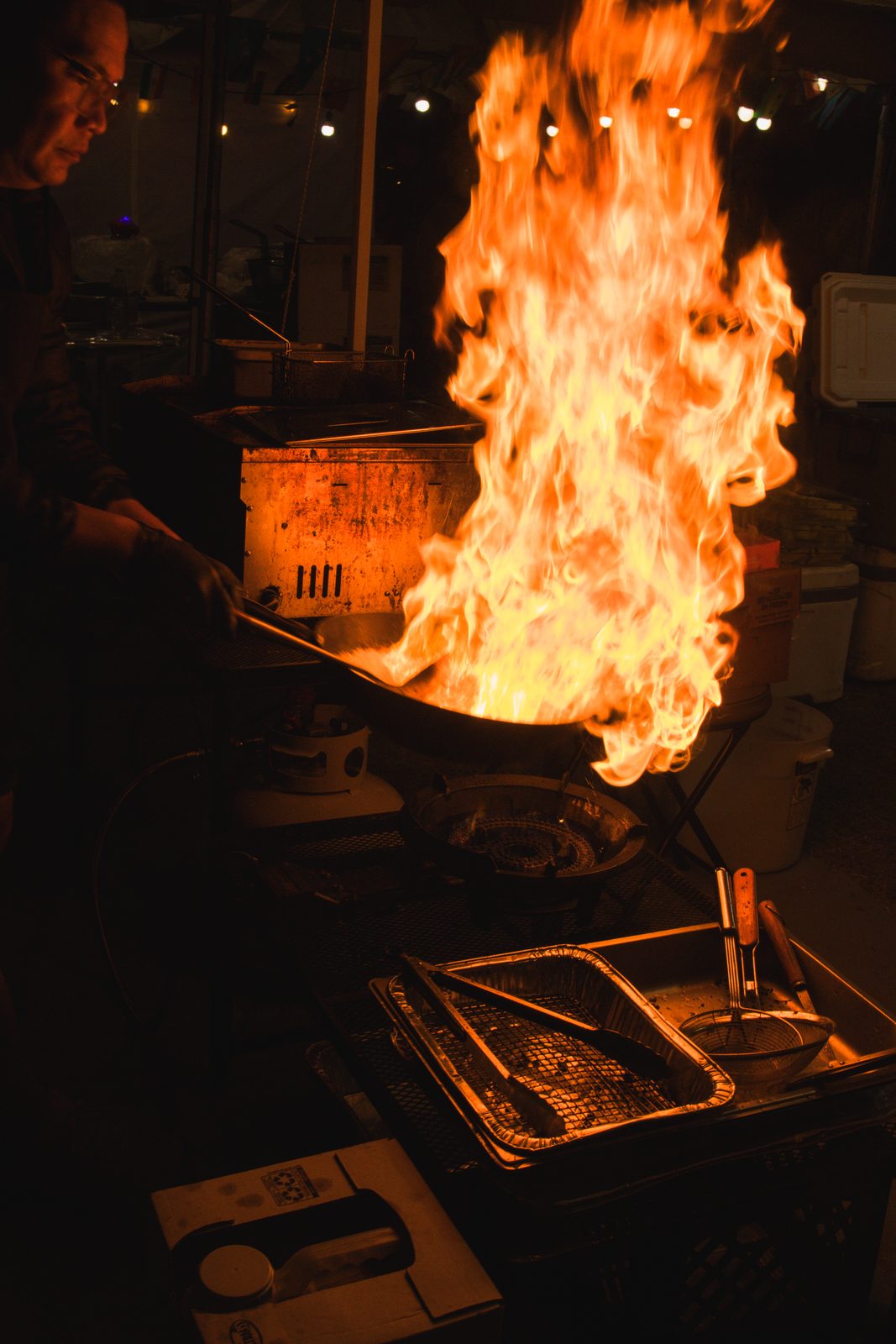 Vendor cooking on an open flame at a night market